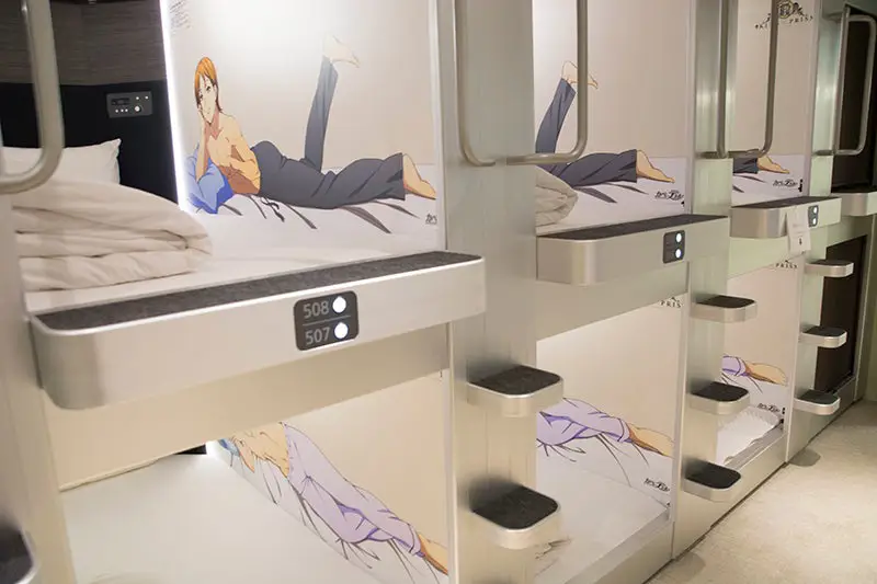 Menikmati Anime di Hotel Kapsul Gambar seseorang menonton anime di hotel kapsul