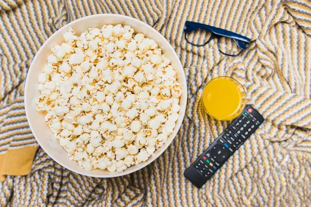 Momen menikmati film dengan popcorn dan remote Momen menikmati film dengan popcorn dan remote